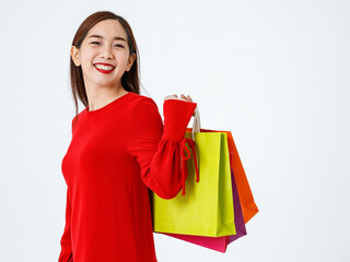 Positive ethnic woman with shopping bags in studio