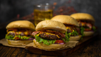 Beef hamburgers served on a wooden board with beer in loft background