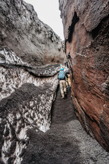 Backpacker in helmet hiking to Etna protected nature area,Sicily,Italy.Adventure outdoor...