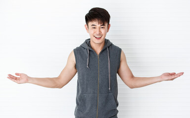 Asian handsome fit smiling man holding hand smartphone taking a selfie.happy gesture wearing sleeveless t-shirt gray sportswear in white background.