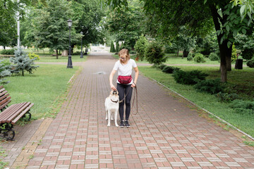 young woman training her dog in a park