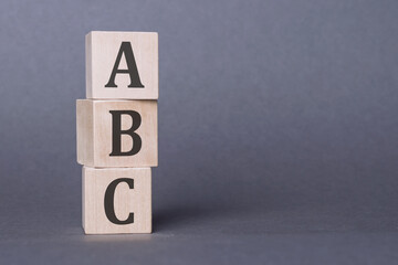 ABC - text, written on wooden blocks, on gray background. - obrazy, fototapety, plakaty