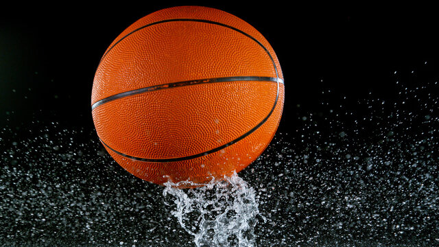 Falling Basketball Ball On Water Surface, Black Background. Top Down View.