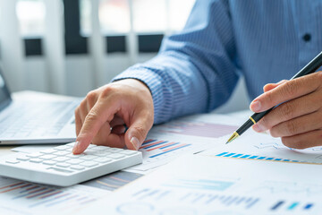 Close up account man hand using calculator for calculate and writing make a note with pen, ..financial reporting and business performance to check investment results