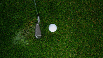 Golf club hitting golf ball on green grass. Freeze motion.
