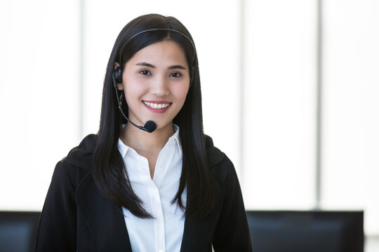 Young And Beautiful Asian Woman Call Center Officer Wearing Microphone Headset And Smile To Camera With A Friendly Face On White Background