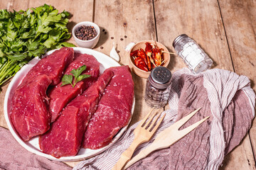 Raw beef steaks on a vintage wooden table