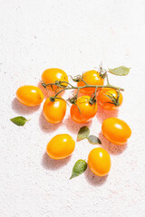 Yellow-orange tomatoes on light plaster background