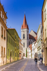 Fototapeta premium Colorful cobblestoned street leading to the Nicholas Church in Znojmo, Czech Republic