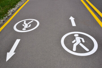 Fototapeta premium On the asphalt road there are signs for pedestrians in both directions, allowing movement for walking