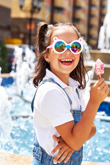 a beautiful cheerful girl eats ice cream in the summer and is happy