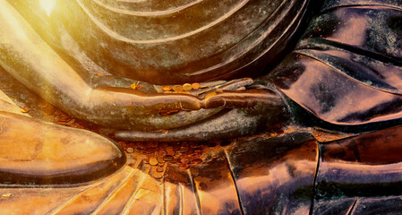 Detail of the lap of a bronze Buddah statue, into which worshippers threw small coins for good luck