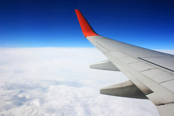 Airplane wing in the blue sky