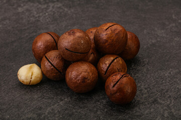 Brown macadamia nut heap over background