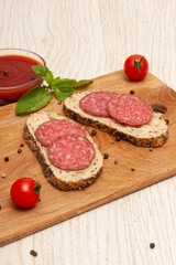 Smoked sausage, ketchup and greens on a wooden board. Top view