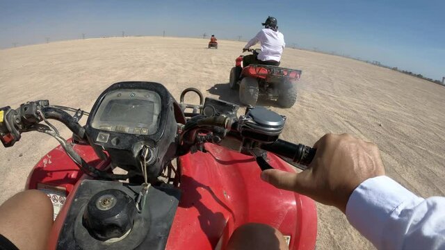 Safari tour with group of people on quad bikes - active leisure in Egypt resorts, driver POV