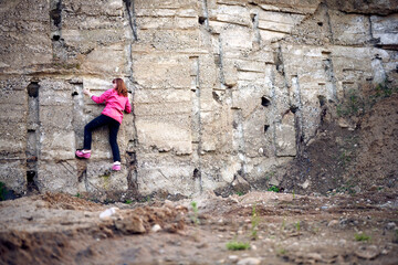 Obraz na płótnie Canvas Woman climbs up the concrete wall