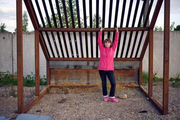 Woman posing near metal structure outdoors