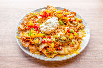 Corn nachos with cream cheese, pulled pork, sliced jelly beans, tricolor peppers and gratin cheddar cheese