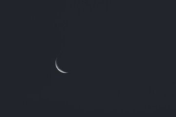 Obraz na płótnie Canvas crescent moon in the night sky shot with telephoto lens.