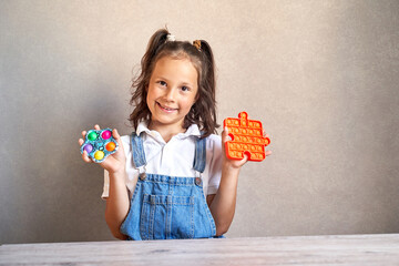 a beautiful girl is smiling holding a pop it hands.