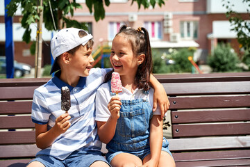 beautiful little boy and girl eating ice cream in summer