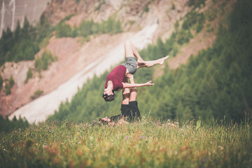 giovane coppia pratica acroyoga all'aperto in natura. Acroyoga. Coppia yoga. Partner yoga