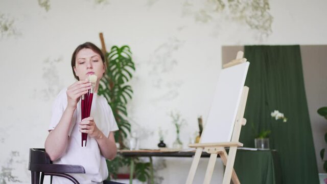 A female artist checks brushes for drawing. Talented painter. Professional creative education
