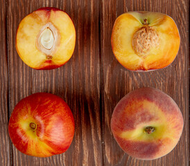top view of fresh ripe sweet nectarines with green leaves on wooden rustic background