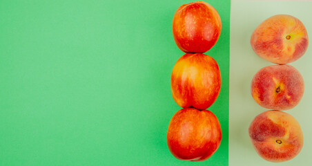 top view of fresh sweet nectarine and peach fruits lined in rows on colored background with copy space