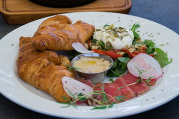Croissants with meat, egg and sauce, restaurant snack