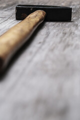 Fragment of a hammer with a wooden handle. Close-up. Selective focus.