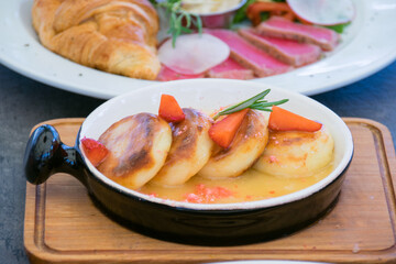 Cheesecakes with strawberries and sauce. Sweet restaurant platter served on a wooden board.