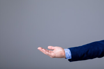 Midsection of caucasian businessman reaching his hand, isolated on grey background