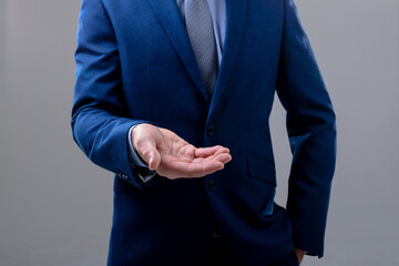 Midsection of caucasian businessman reaching his hand, isolated on grey background