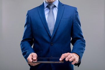 Midsection of caucasian businessman using tablet, isolated on grey background