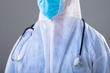 Caucasian male doctor wearing ppe suit, isolated on grey background