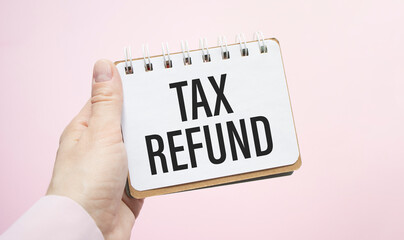 Closeup on businessman holding a card with text TAX REFUNDS, business concept image with soft focus background and vintage tone