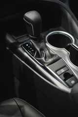 Fototapeta na wymiar car cup holders between back seats, close up view, luxury car interior