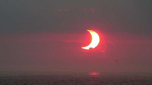 Crescent-shaped sun at dawn during a partial solar eclipse at 2x normal speed.