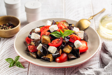 Summer salad with feta cheese, baked eggplant and fresh tomatoes, basil, olive oil. Light...