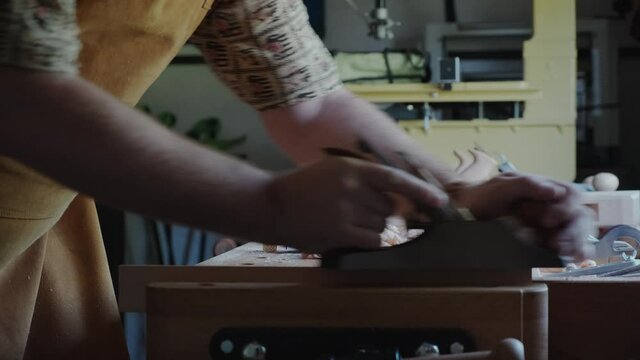 The carpenter works with a plane.