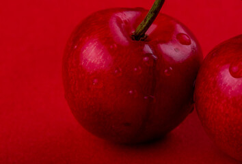 close up view of red ripe cherry with water drops isolated on red background