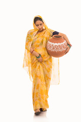 A woman holding a matki by her waist looking downwards.