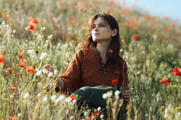 Beautiful girl sitting in the grass and poppies - 442508605