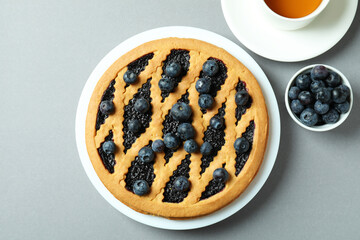 Concept of delicious breakfast with blueberry pie on gray background