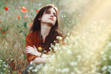 Beautiful girl sitting in the grass and poppies - 442508648