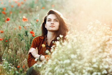 Beautiful girl sitting in the grass and poppies - 442508670