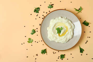 Plate of mashed potatoes and spices on beige background