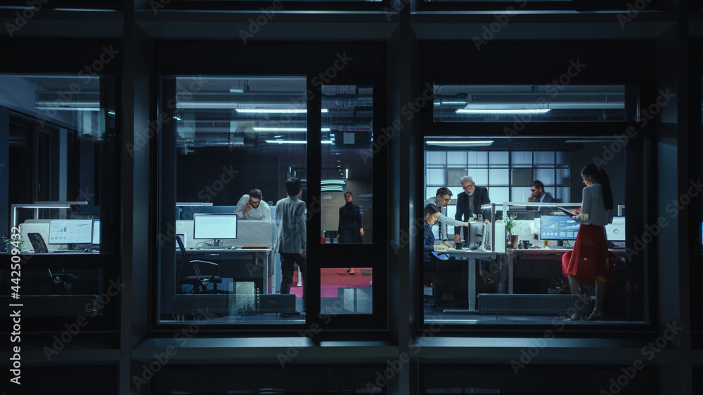 Poster shot from outside the window: businessmen and businesswomen working in the office. managers and spec